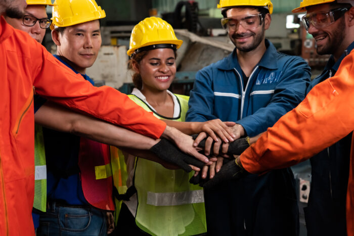 Skillful worker stand together showing teamwork in the factory .